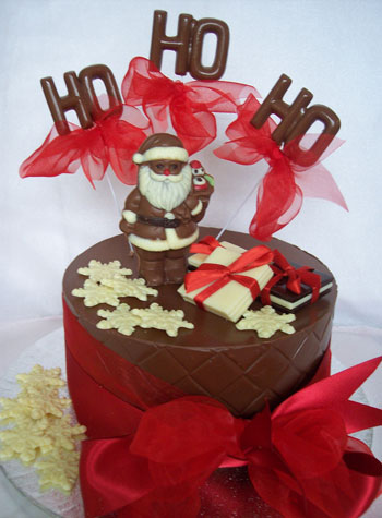 a picture of milk chocolate santa on singe milk chocolate tier, decorated with white chocolate and pink ribbon