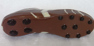 a picture of a milk chocolate football boot decorated with white and dark chocolate