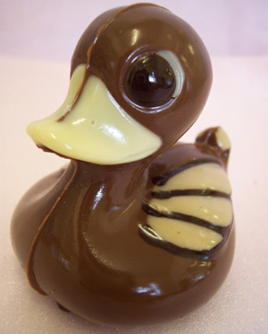 a picture of a milk chocolate duck decorated with white and dark chocolate