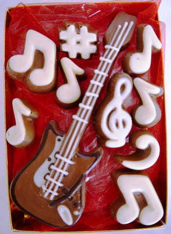 a picture of a milk chocolate guitar decorated with white and dark chocolate