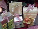 a picture of seven small wedding favour boxes, differently coloured and each tied with ribbon