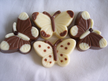 a picture of four chocolate butterflies, decorated with milk and white chocolate