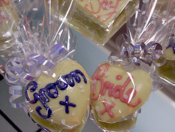 a picture of two small chocolate love hearts, one with 'Groom' and one with 'Bride' written in coloured chocolate.