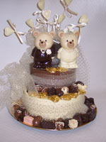 milk and white chocolate wedding teddies decorated with love hearts and ribbon on a chocolate tier